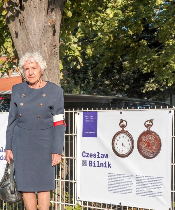 Wanda Różycka-Bilnik vor dem Plakat, das ihren Vater Czesław zeigt